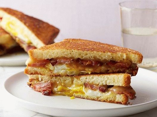 Foto vrući sendvič sa sirom, slaninom, jajetom i javorovim sirupom