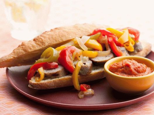 Foto hot-dogovi s kobasicama na žaru, slatkim paprom, lukom i curry umakom