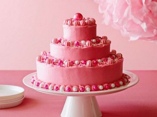 Fotografija rođendanske torte sa jarko ružičastom glazurom od maslaca