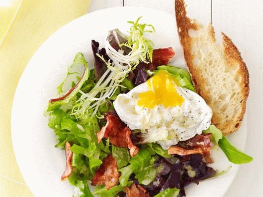 Foto salata s poširanim jajima i slaninom u kafiću